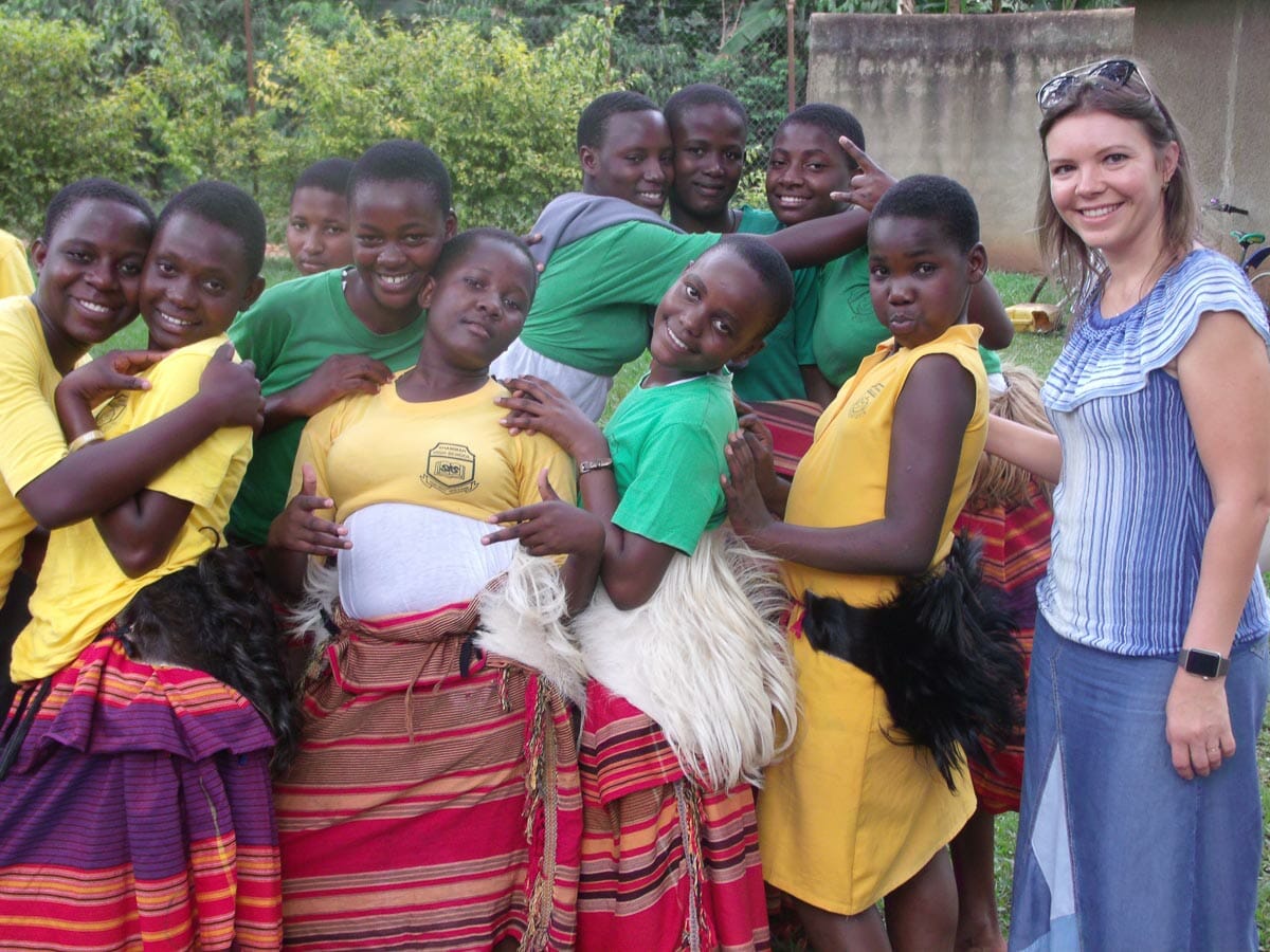 Jane Sinyagin with students in traditional dress at a partner school in Uganda
