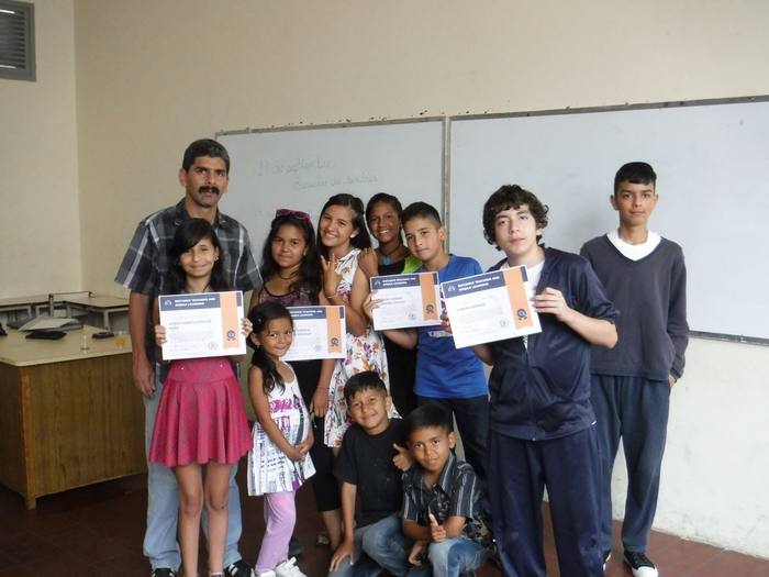 Students and their teacher in Venezuela holding up English program certificates