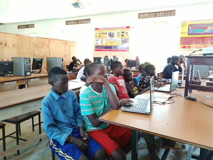 Students working at desktop computers in a school computer lab in Uganda
