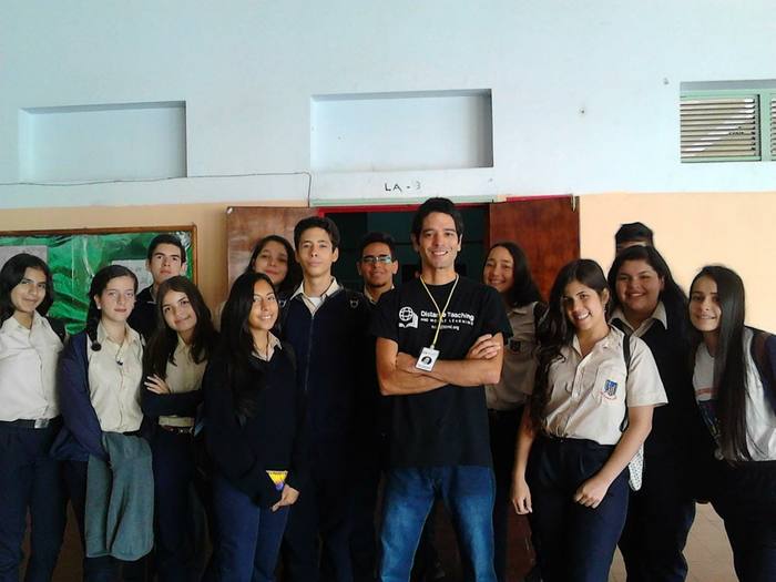 Students in school uniforms posing with JAAS volunteers after a program session