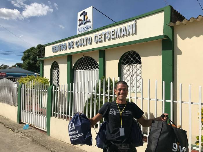 A volunteer carrying bags of donated supplies outside a community center in Colombia